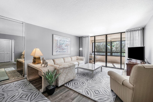 living room with hardwood / wood-style flooring, floor to ceiling windows, and a textured ceiling