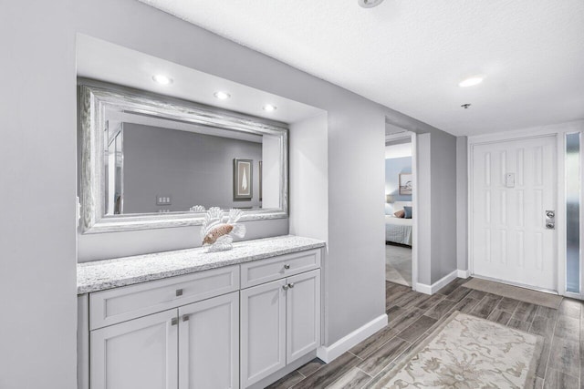 interior space featuring hardwood / wood-style flooring, vanity, and a textured ceiling