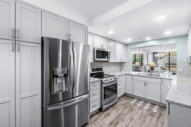 kitchen featuring tasteful backsplash, sink, wood-type flooring, and appliances with stainless steel finishes