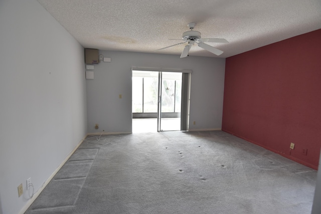 carpeted spare room with a textured ceiling and ceiling fan