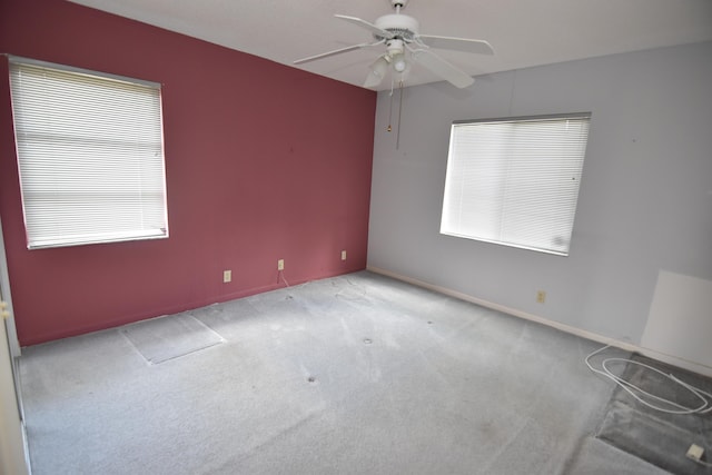 unfurnished room featuring light colored carpet, ceiling fan, and a healthy amount of sunlight