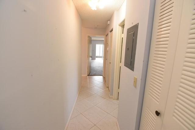 hall featuring electric panel, light tile patterned floors, and a textured ceiling