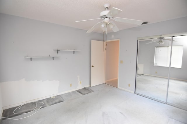 unfurnished bedroom featuring ceiling fan, light colored carpet, a textured ceiling, and a closet