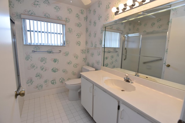 bathroom with tile patterned flooring, vanity, toilet, and a shower with door