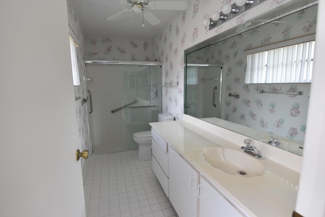 bathroom featuring ceiling fan, tile patterned flooring, toilet, vanity, and a shower with shower door