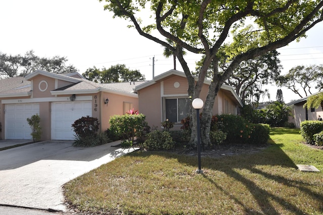 ranch-style home featuring a front lawn and a garage