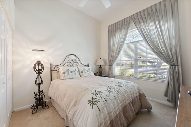 bedroom with multiple windows, a closet, ceiling fan, and light colored carpet