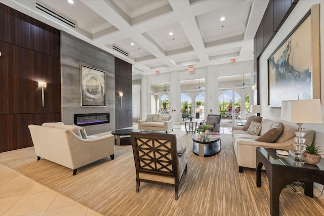 living room with a fireplace, beamed ceiling, ceiling fan, light tile patterned floors, and coffered ceiling