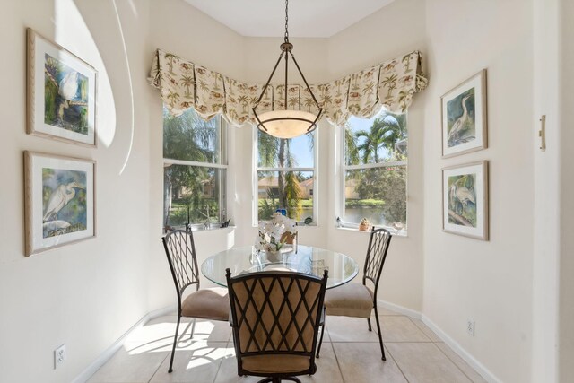 dining space with light tile patterned flooring and a chandelier