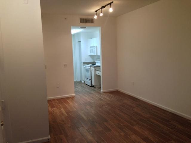 unfurnished room with dark wood-type flooring