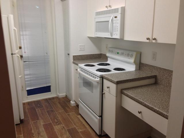 kitchen featuring white cabinetry, dark hardwood / wood-style flooring, and white appliances