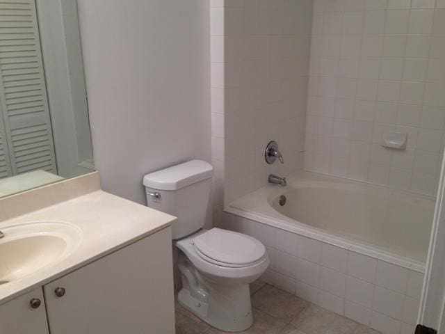 full bathroom with tile patterned flooring, vanity, toilet, and tiled shower / bath