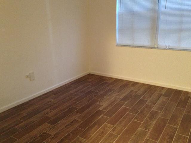 empty room featuring dark wood-type flooring