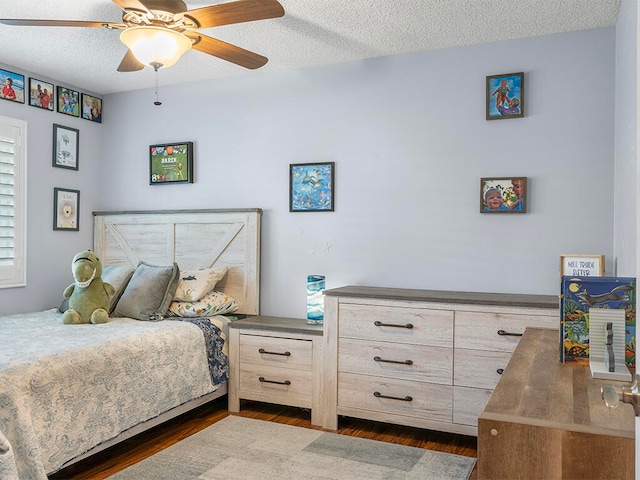 bedroom featuring ceiling fan, dark hardwood / wood-style floors, and a textured ceiling