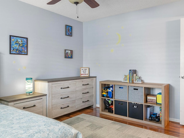 bedroom featuring a textured ceiling, ceiling fan, and dark wood-type flooring