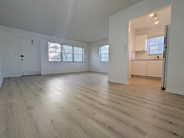 unfurnished living room with light hardwood / wood-style floors and a healthy amount of sunlight