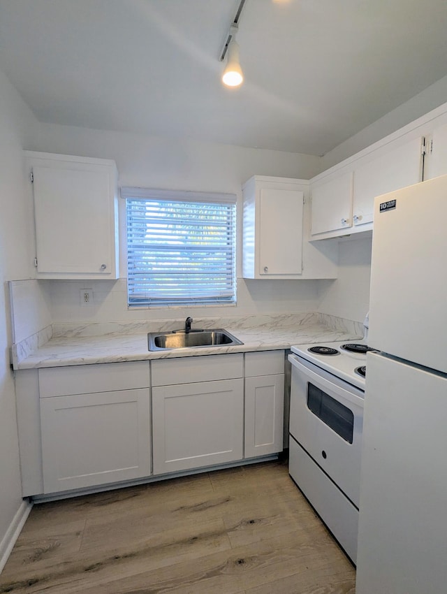 kitchen with sink, white cabinets, track lighting, and white appliances