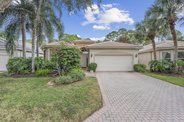 mediterranean / spanish house with a front yard and a garage