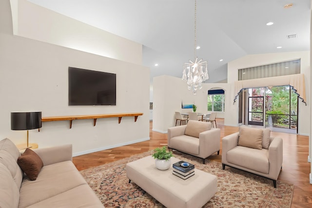 living room featuring high vaulted ceiling, light hardwood / wood-style flooring, and a notable chandelier