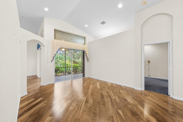 spare room featuring hardwood / wood-style flooring and high vaulted ceiling