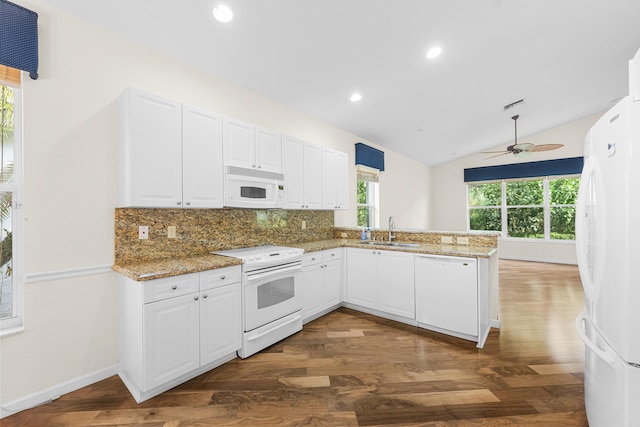 kitchen with kitchen peninsula, dark hardwood / wood-style flooring, white appliances, vaulted ceiling, and white cabinetry