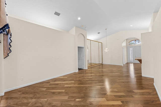 spare room with dark hardwood / wood-style floors and vaulted ceiling