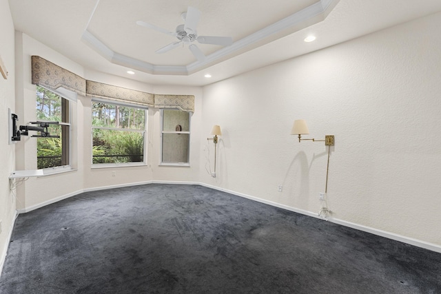 carpeted empty room with a tray ceiling, ceiling fan, and crown molding