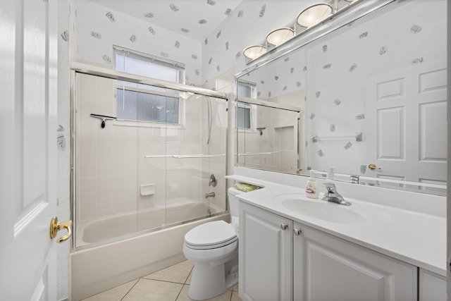 full bathroom with toilet, vanity, tile patterned floors, and bath / shower combo with glass door