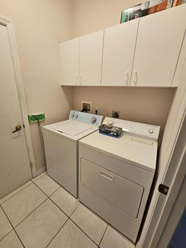 laundry area featuring light tile patterned floors, cabinets, and independent washer and dryer