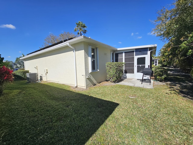 back of house with central air condition unit, a yard, and a patio area