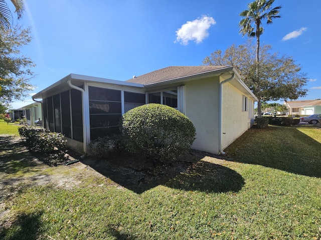 view of property exterior with a yard and a sunroom