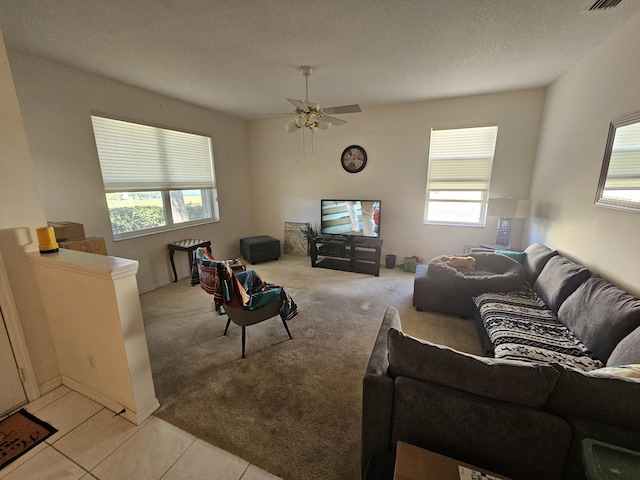 living room featuring light tile patterned floors, ceiling fan, and a wealth of natural light