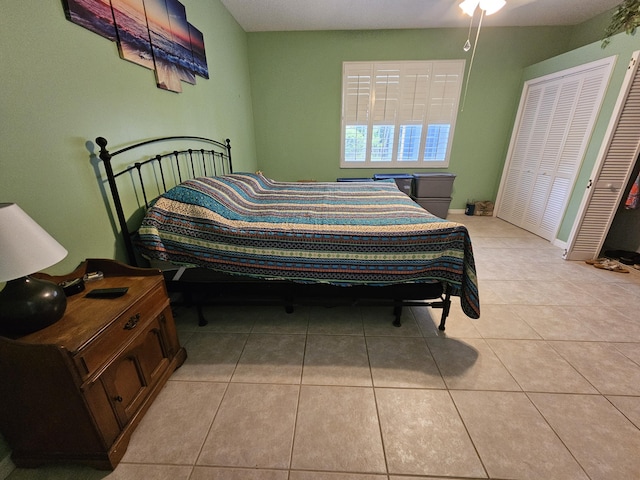 bedroom with light tile patterned flooring and a closet