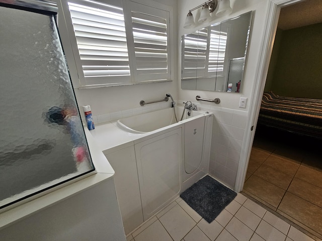 bathroom with tile patterned flooring and shower with separate bathtub