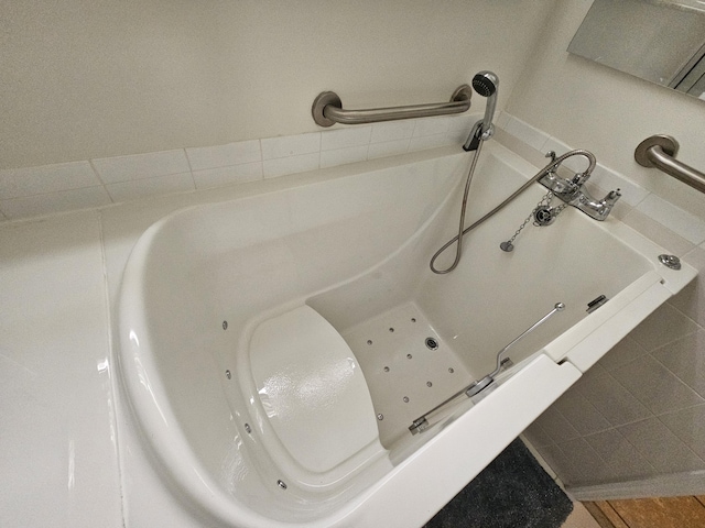 bathroom with tile patterned floors and a tub to relax in