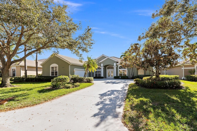 ranch-style home featuring a garage and a front lawn