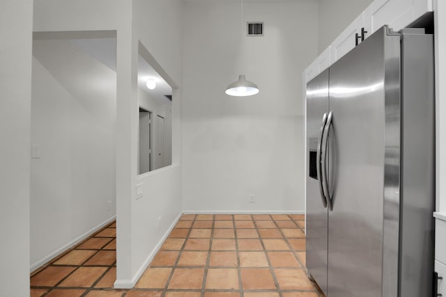 kitchen featuring white cabinetry, stainless steel fridge with ice dispenser, and tile patterned flooring