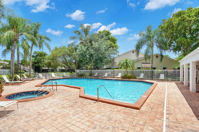 view of swimming pool with a patio area and a community hot tub