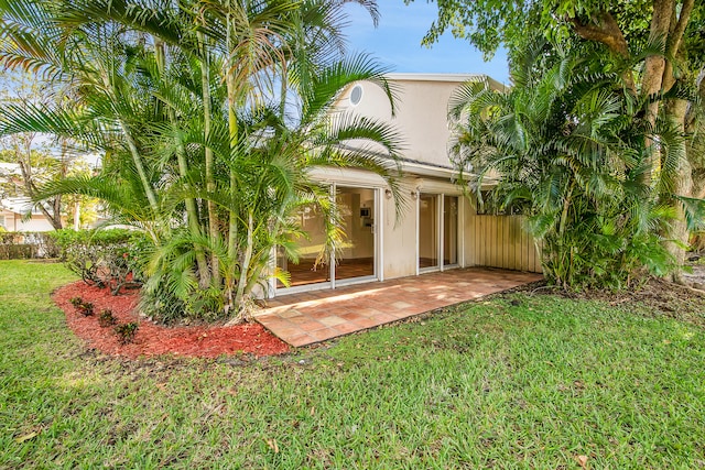 back of property featuring a lawn and a patio area