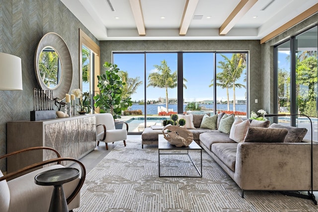 living room featuring beamed ceiling and a water view