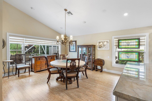 dining area featuring high vaulted ceiling, light hardwood / wood-style flooring, and a notable chandelier