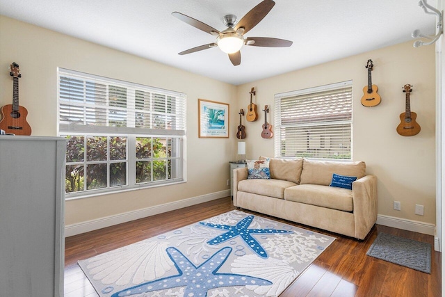 living room featuring ceiling fan, a healthy amount of sunlight, and dark wood-type flooring