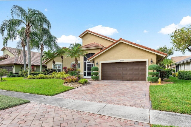 mediterranean / spanish home with a garage and a front lawn