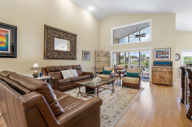 living room featuring light hardwood / wood-style floors, high vaulted ceiling, and ceiling fan