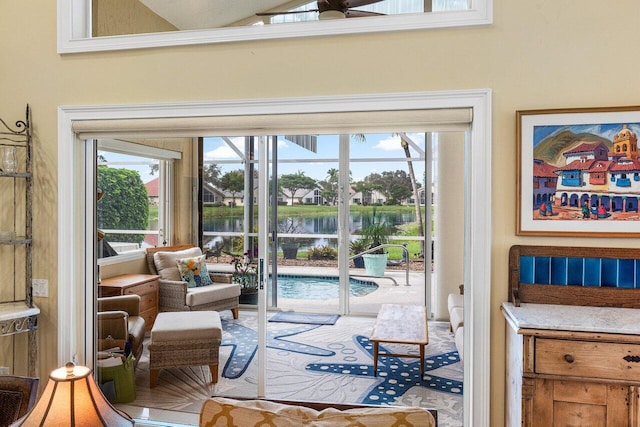 doorway to outside with a water view, ceiling fan, and lofted ceiling