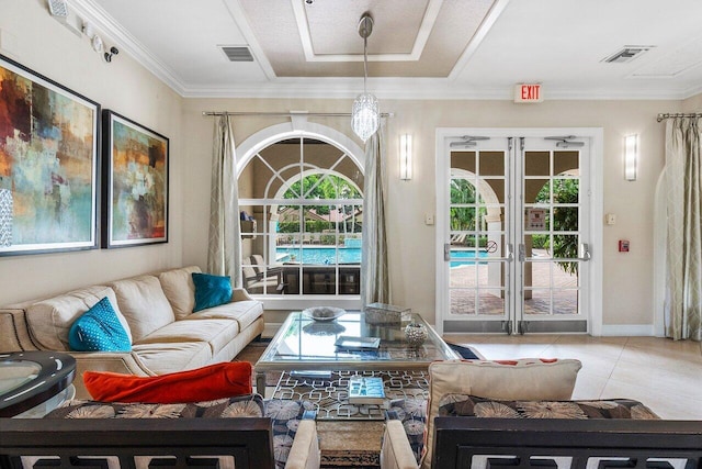 living room with light tile patterned floors, ornamental molding, and an inviting chandelier