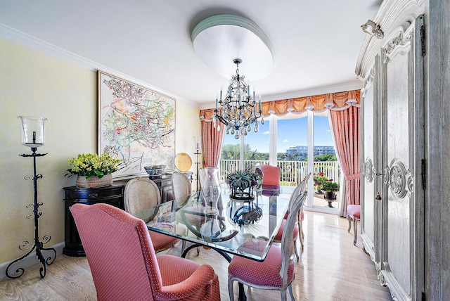 dining room featuring light hardwood / wood-style floors, ornamental molding, and an inviting chandelier