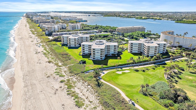 birds eye view of property with a water view and a beach view