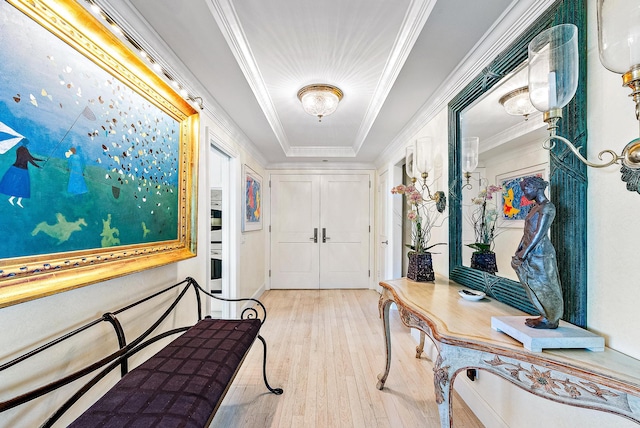 hall with light wood-type flooring and ornamental molding