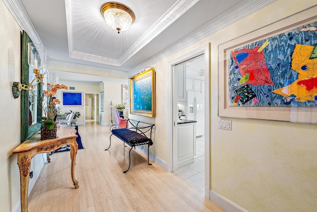 hallway with light hardwood / wood-style floors and crown molding